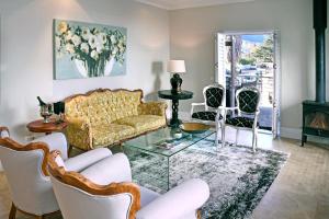 a living room with a couch and chairs at Le Petit Bijou Boutique Apartments - Solar Power in Franschhoek