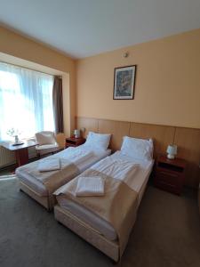 a hotel room with two beds and a window at D-Hotel in Gyula