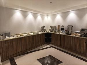 a restaurant with a counter with food on it at W Platinum Hotel in Al Madinah