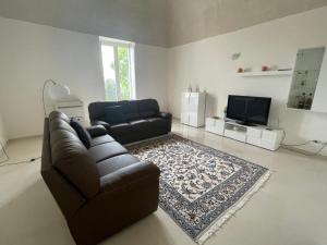 a living room with a couch and a tv at Antica Masseria Malvezzi in Matera