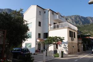 un edificio blanco al lado de una calle en Apartments by the sea Drvenik Donja vala, Makarska - 6675, en Drvenik