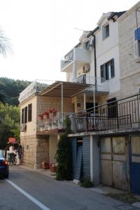 un edificio con balcones al lado de una calle en Apartments by the sea Drvenik Donja vala, Makarska - 6675, en Drvenik