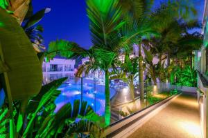 un complejo con piscina y palmeras por la noche en Tasia Maris Oasis, en Ayia Napa