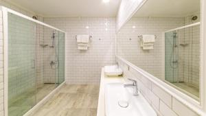 a white bathroom with a sink and a shower at Hotel Mavi Beyaz in Palamutbuku