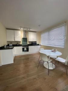 a kitchen with a table and chairs in a room at Westminster House in Slough