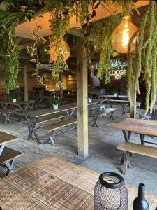 a patio with wooden tables and benches and plants at The Huntsman in Cheadle