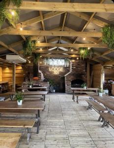 an empty restaurant with wooden tables and benches at The Huntsman in Cheadle