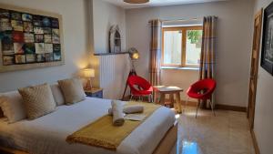 a bedroom with a bed and two red chairs at Fab View in Dingle +125 photos
