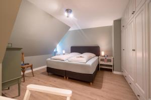 ein kleines Schlafzimmer mit einem Bett im Dachgeschoss in der Unterkunft Luettliv-Huus II in Wyk auf Föhr