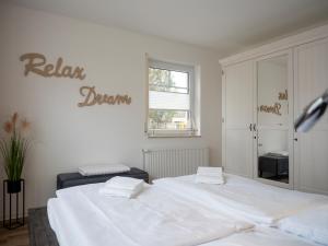 a bedroom with two beds and a sign that reads relax drown at Darßer Weg FW 9 in Zingst