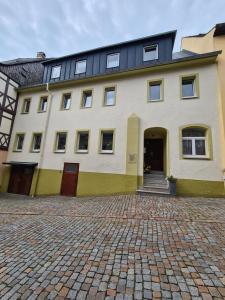 a large white building with a black roof at Ferienwohnung Augustusburg in Augustusburg