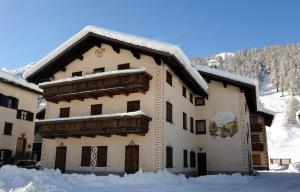 un edificio coperto di neve con sopra della neve di Livigno Chalets a Livigno