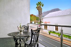 a table and chairs on a balcony with a view at Le Petit Bijou Boutique Apartments - Solar Power in Franschhoek