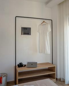 Aiora Suites by Booking Kottas في بساكوديا: مرآة في غرفة مع ثوب أبيض معلق على الحائط