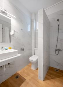 uma casa de banho branca com um lavatório e um WC em Aiora Suites by Booking Kottas em Psakoudia