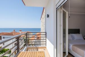 uma varanda com uma cama e vista para o oceano em Aiora Suites by Booking Kottas em Psakoudia