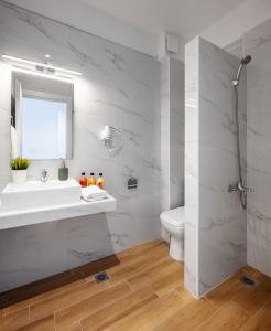 Aiora Suites by Booking Kottas في بساكوديا: حمام أبيض مع حوض ومرحاض