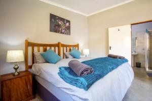 a bedroom with a bed with a blue blanket on it at Rivendell Trout Estate in Lydenburg