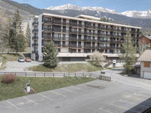 un edificio de apartamentos con un aparcamiento enfrente en Appartement Saint-Chaffrey , 2 pièces, 6 personnes - FR-1-330E-26, en Saint-Chaffrey