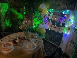 una mesa con un pastel y un feliz anuncio de Año Nuevo y globos en St. John Island View Pensionne en El Nido