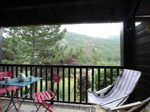 d'une terrasse avec 2 chaises et une table sur un balcon. dans l'établissement Appartement Saint-Chaffrey , 3 pièces, 6 personnes - FR-1-330E-106, à Saint-Chaffrey