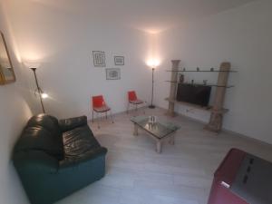 un salon avec un canapé, des fauteuils et une télévision dans l'établissement La Casa del Pellegrino, à Tuscania