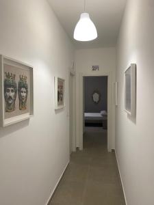 a hallway with paintings on the walls of a room at AEROPORTO KATANÈ ROOMS in Catania