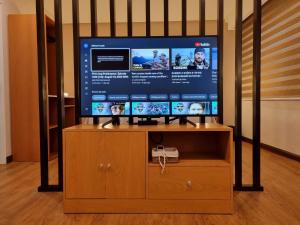 a flat screen tv sitting on top of a wooden entertainment center at ALVEA HOTEL in Puerto Princesa City