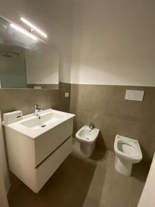 uma casa de banho com um lavatório e um WC em AEROPORTO KATANÈ ROOMS em Catânia