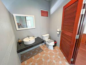 y baño con lavabo, aseo y espejo. en TropiCoco Beach Resort Koh Phangan, en Haad Yao