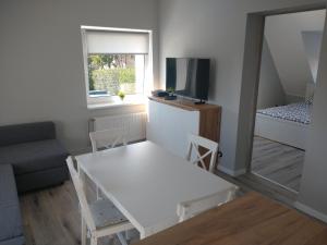 un piccolo soggiorno con tavolo bianco e divano di Stara Oliwa a Danzica