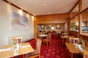 a restaurant with wooden walls and tables and chairs at Old Hunstanton Le Strange Arms Hotel in Hunstanton