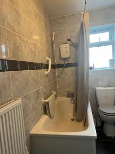 a bathroom with a bath tub and a toilet at Medway Stay in Chatham