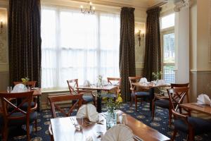 a dining room with tables and chairs and a window at Old Hunstanton Le Strange Arms Hotel in Hunstanton