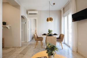 salon ze stołem jadalnym i krzesłami w obiekcie Magno Apartments Guadalquivir Terrace w Sewilli