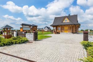 a small wooden house with a playground in a field at Domki Tatry in Szaflary