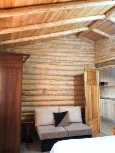 een kamer met een bank in een houten muur bij Lodges VEIS in Kamenicë