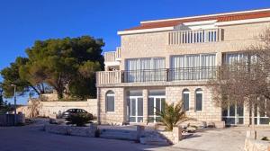 a large brick building with a car parked in front of it at Seaside holiday house Razanj, Rogoznica - 19159 in Ražanj