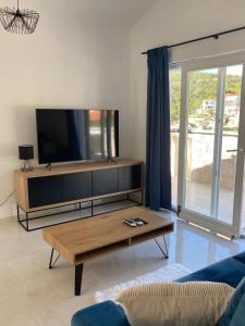 a living room with a tv and a coffee table at Seaside holiday house Razanj, Rogoznica - 19159 in Ražanj