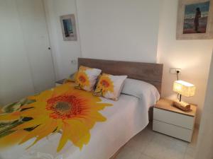 a bedroom with a bed with a sunflower on it at VERANO AZUL in Benidorm +7 photos