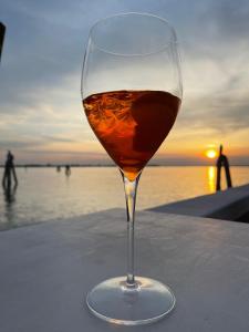 a glass of wine sitting on a table near the ocean at Antica Dogana in Cavallino-Treporti
