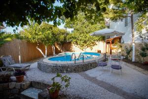 una piscina en un patio con sillas y sombrilla en Seafalios Villa, en La Canea