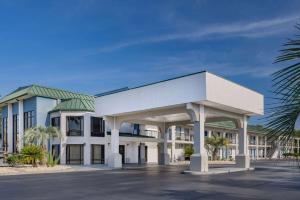 een groot wit gebouw met een groen dak bij Days Inn & Suites by Wyndham Savannah Midtown in Savannah