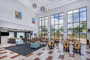 una grande stanza con tavoli, sedie e finestre di Days Inn & Suites by Wyndham Savannah Midtown a Savannah