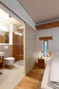 uma casa de banho com uma cama, um chuveiro e um WC. em Gasthof zum weissen Rössli em Erschwil
