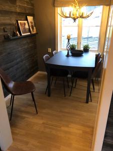 a dining room with a black table and chairs at COZY COTTAGE-VILLA CLOSE TO WINTER SPORTS, MOUNTAIN & LAKE - 10 Pers in Mörsil