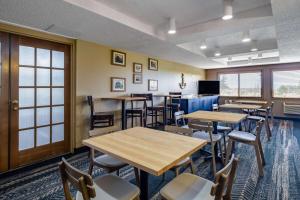 a dining room with tables and chairs and a tv at AmericInn by Wyndham Two Harbors Near Lake Superior in Two Harbors