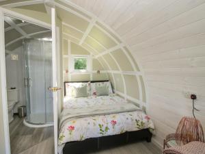 a bed in a room with an arched ceiling at Cherry Pod in Shrewsbury