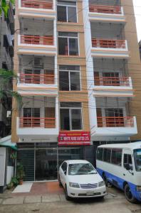 dos coches estacionados frente a un edificio en White Rose Suites Ltd, en Dhaka