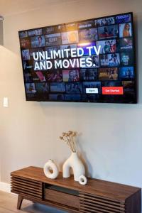 a tv hanging on a wall above a wooden table at 2BR Downtown Convention Center Near Attractions in Seattle